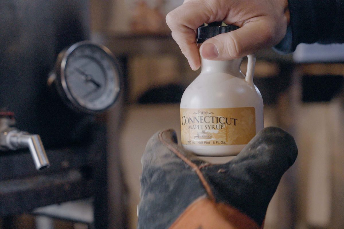 filling a small jug of maple syrup